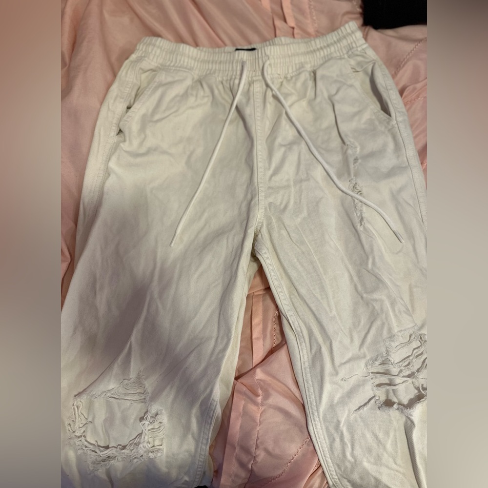 Cream colored sweat pants with rips